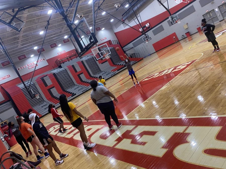 Members of the girls basketball team practice in Alton Highs gym. Their season  resumed on Jan. 28, 2021. Kahliyah Goree is at the free throw shooting a 2-pointer for the drill, while her other teammates are waiting to get their turn. Savannah MCrruray said,   ¨With it being my senior, year I was planning on hitting the 1,000 points mark. Me and My teammates were all going to work together to make sure it was going to happen. I also wanted to finish this year off strong with more winning games then we’ve ever had.