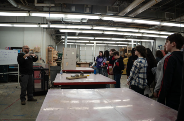 Home and Auto teacher Derrick Davault introduces his courses while a group of 8th graders listens intently.